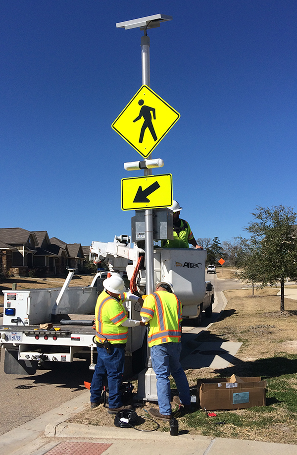 workers adjusting traffic warning sign in neighborhood as a part of traffic calming procedures in in Bryan, Texas