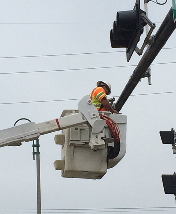 worker adjusting traffic stoplight in in Bryan, Texas